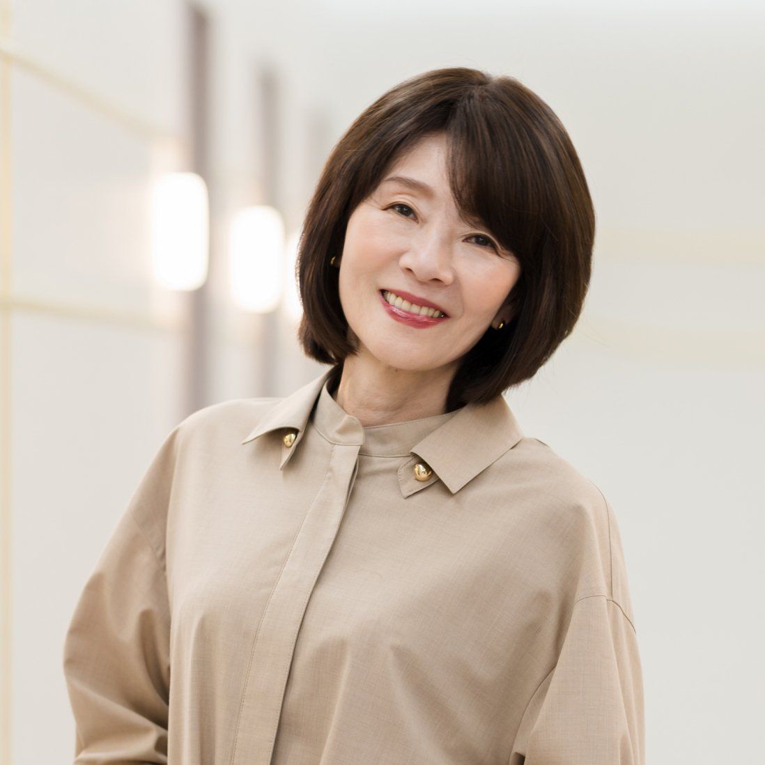 ボブスタイルのウィッグを着けて微笑む女性