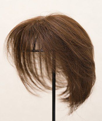 スタイリストがウィッグを浅井さんの髪型に合わせて整えている様子